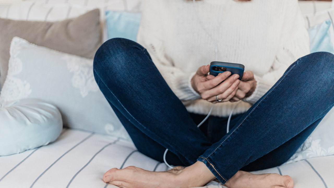 Sinead Doohan at the Happy Me with her legs crossed listening to an audio on her mobile phone
