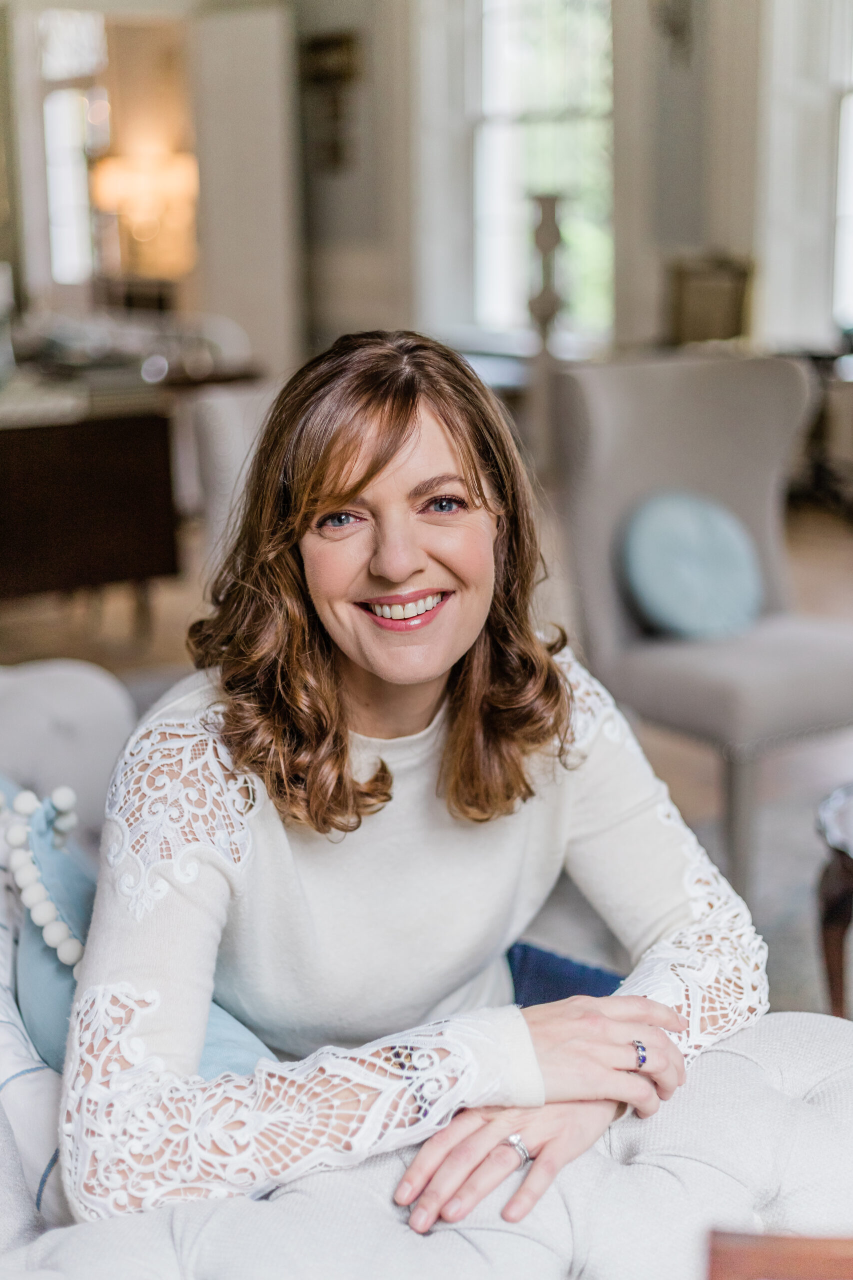 Sinead Doohan at The Happy Me, dressed in a cream blazer and sparkly top, leaning against a wall and smiling
